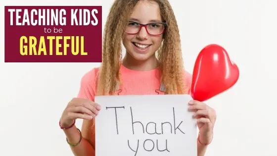 girl with thank you sign and text overlay - teaching kids to be grateful