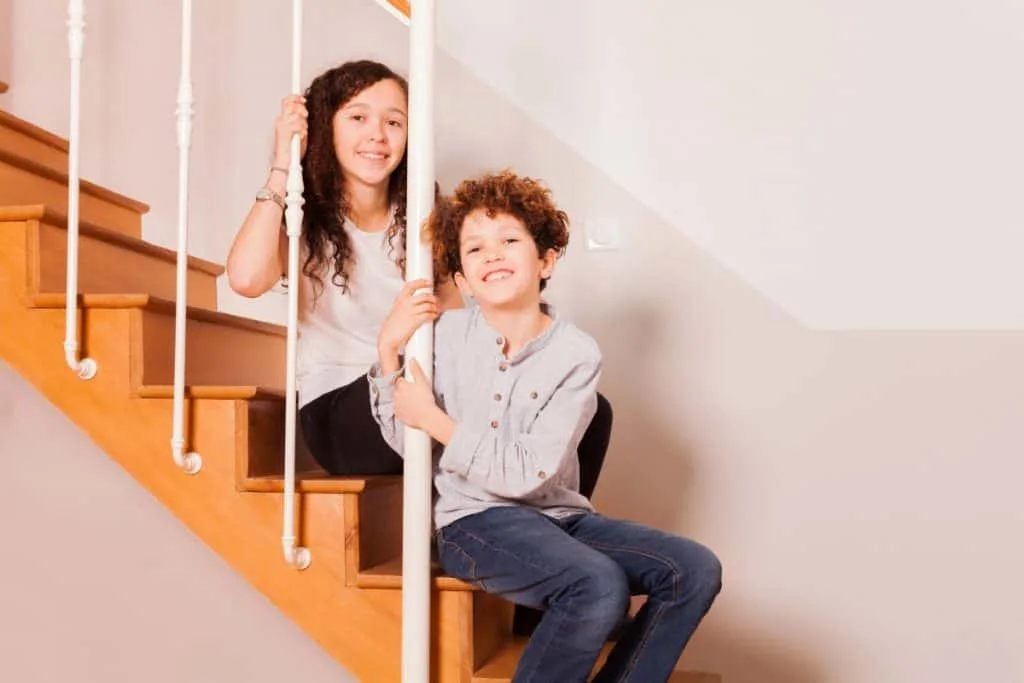 How To Help Siblings Get Along For Good 3 boy and girl sitting on stairs smiling