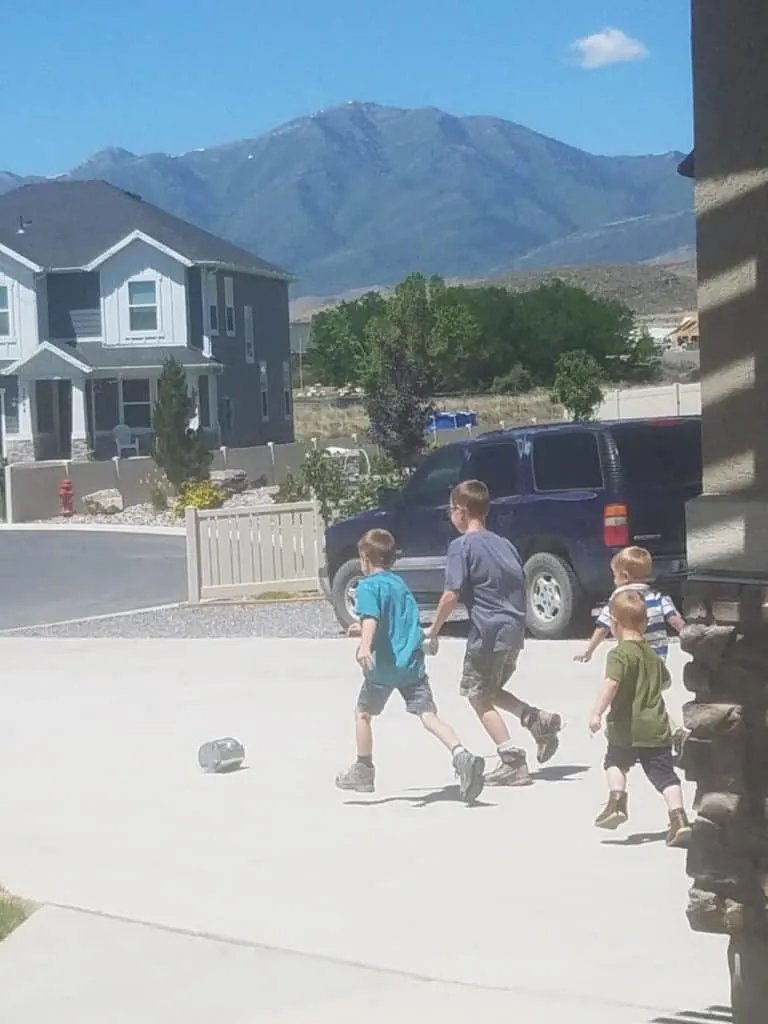 Free Tin Can Ice Cream Science Experiment and STEM Activity 18 A group of kids chasing a can of tin can ice cream that is rolling down the driveway