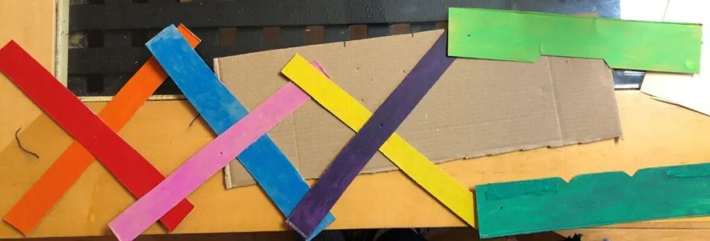 Chomping Cardboard Dragon STEAM Craft for Kids 10 laying out strips to assemble chomping cardboard dragon