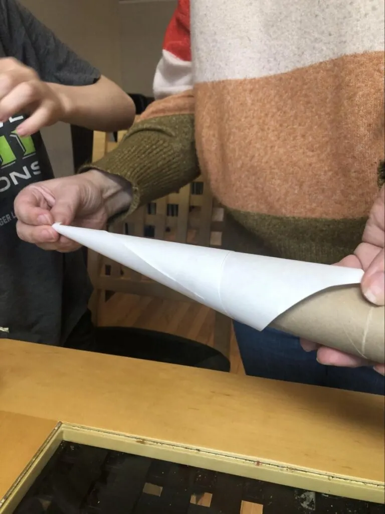 Paper Mache Dragon STEM and Craft Project Tutorial 5 paper cone being wrapped around a toilet paper roll for a paper mache dragon