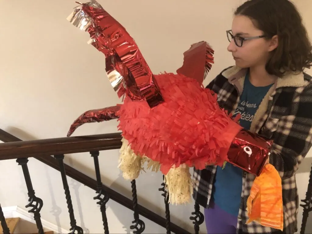 Paper Mache Dragon STEM and Craft Project Tutorial 20 teenage girl holding completed red dragon out of paper mache
